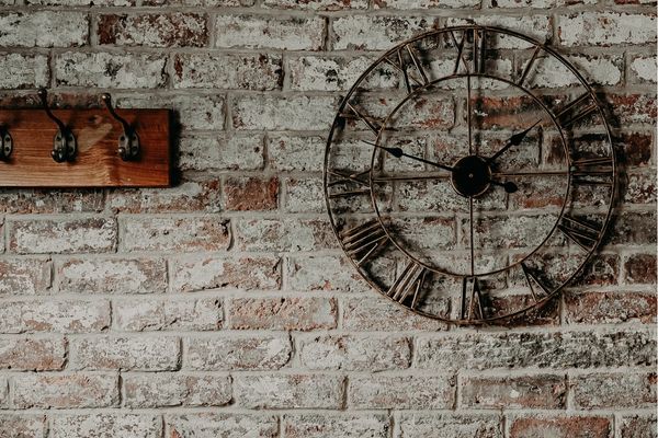 large clock on a brick wall for keeping track of the time when you are time blocking your day