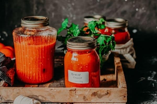 ball canning jars with tomato sauce in them