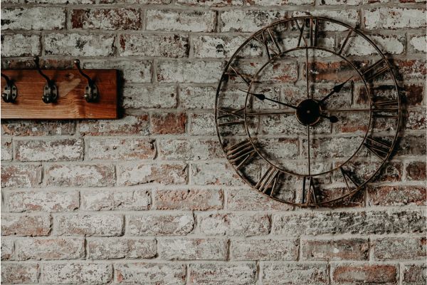 large clock on a brick wall to help keep track of time while planning ahead